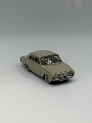 Light gray die-cast Ford Taunus sedan in 1/87 scale with black interior details and visible license plate.