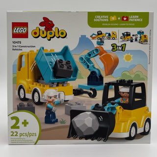 LEGO Duplo construction set with yellow dump truck, blue excavator, yellow bulldozer, two minifigures, and black bricks on sa