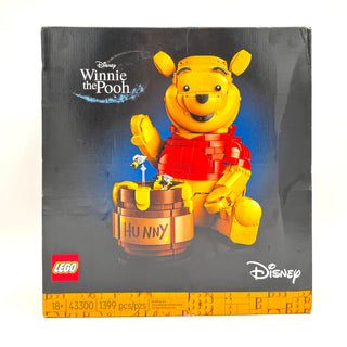 LEGO Disney Winnie the Pooh set box featuring yellow bear figure in red shirt next to honey pot, 1399 pieces.