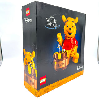 LEGO Disney Winnie the Pooh set box featuring Pooh in red shirt with honey pot and minifigure against dark background.
