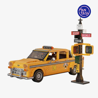 Yellow toy taxi cab with checkered stripe, accompanying traffic light and street sign accessories.